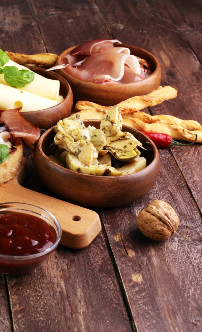 Antipasti-Brett mit verschiedenen Dips und Bruschette auf einem Holztisch