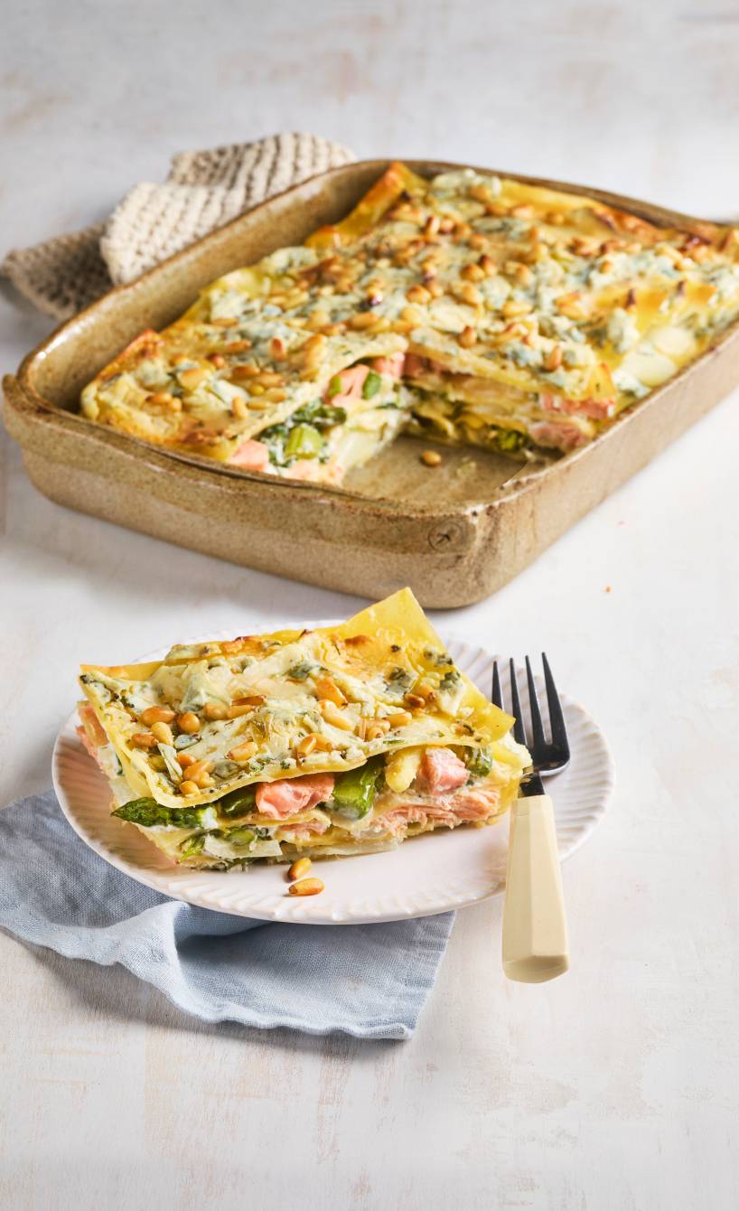 Gebackene Spargel-Lachs-Lasagne angeschnitten auf einem Küchentisch
