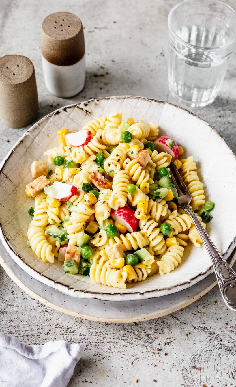 Veganer Nudelsalat mit Tofu und selbstgemachter Mayonnaise angerichtet auf einem tiefen Teller