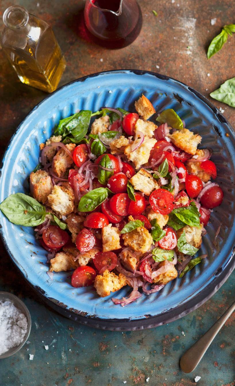 Veganer Panzanella Brotsalat angerichtet in einer Salatschüssel auf einem Tisch