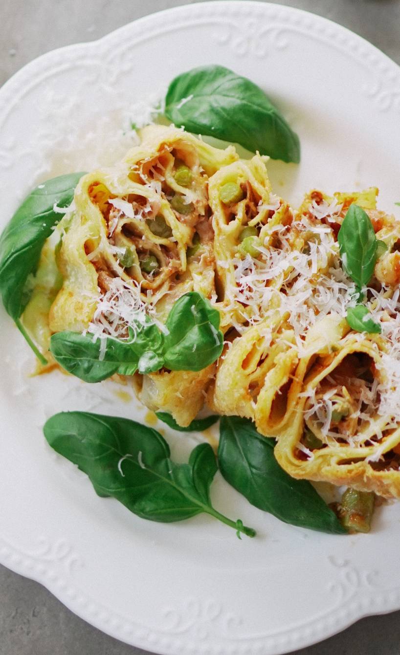 Spargellasagne-Häppchen angerichtet mit frischem Basilikum auf einem Teller