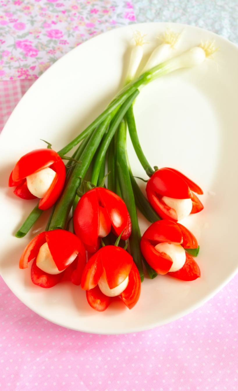 Tomaten Mozzarella Tulpenstrauß mit Frühlingszwiebeln angerichtet auf einer Vorspeisenplatte