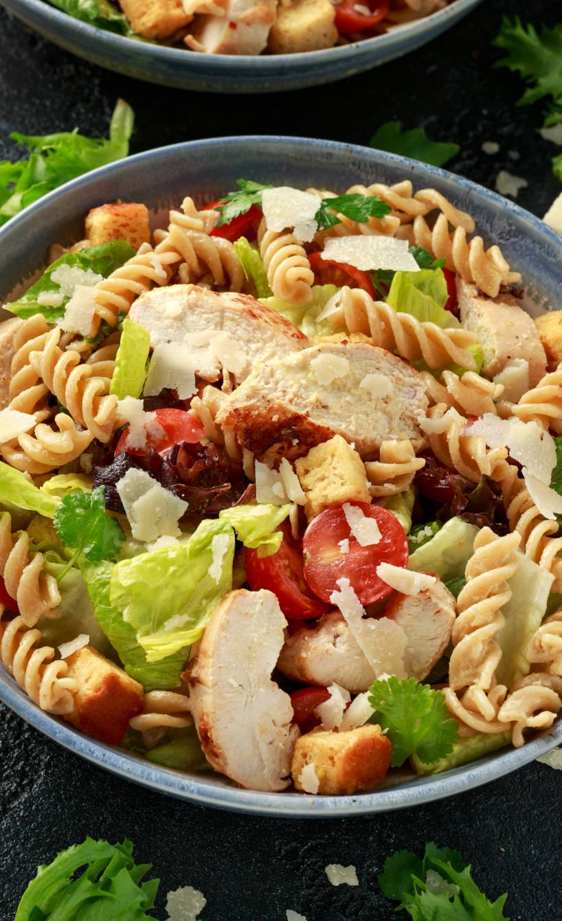 Salat aus Resten von Nudeln, Brot und Hähnchen angerichtet mit Cherrytomaten in einer Salatschüssel