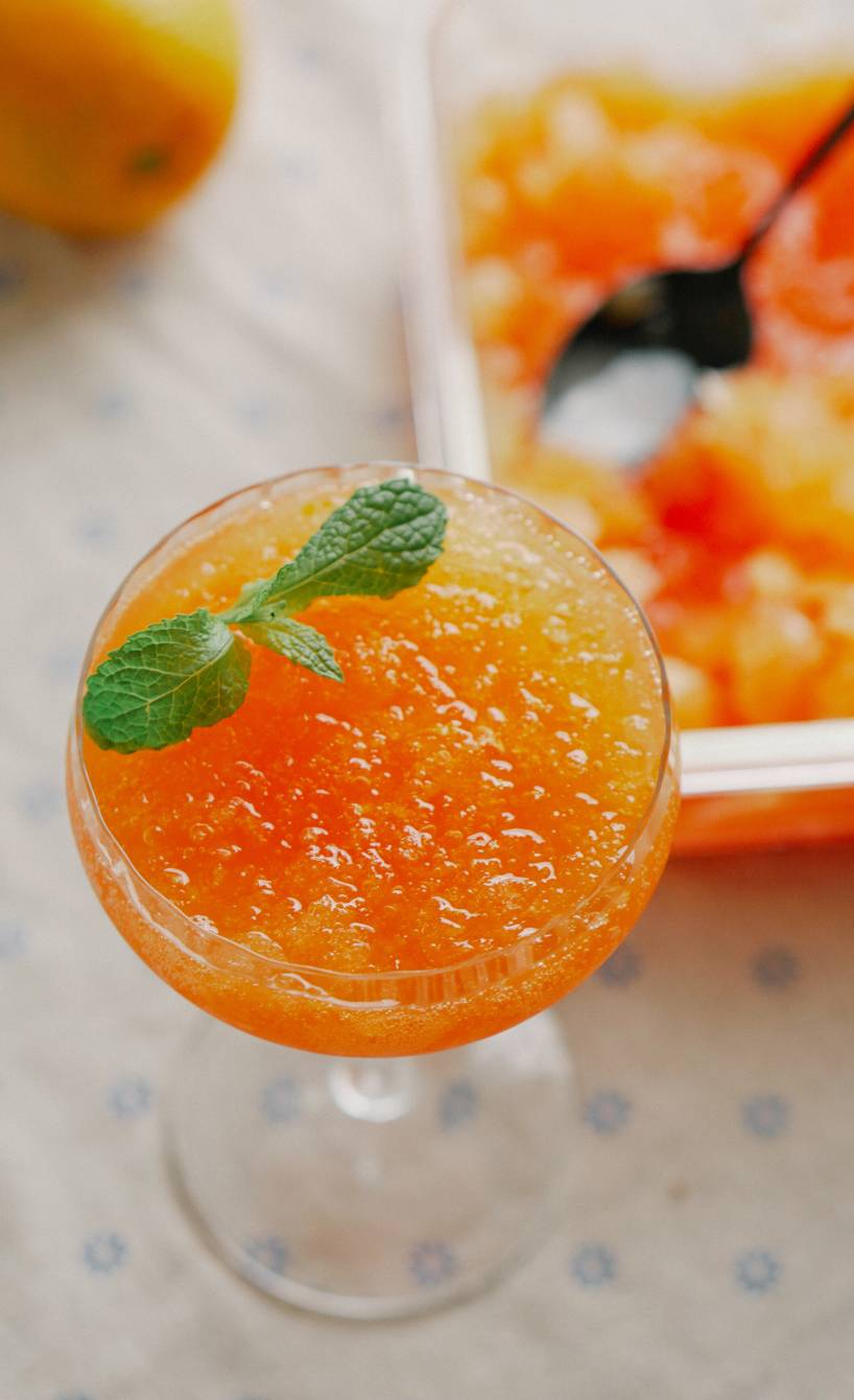 Aperol-Spritz-Sorbet in einem Chammpagnerglas garniert mit frischer Minze