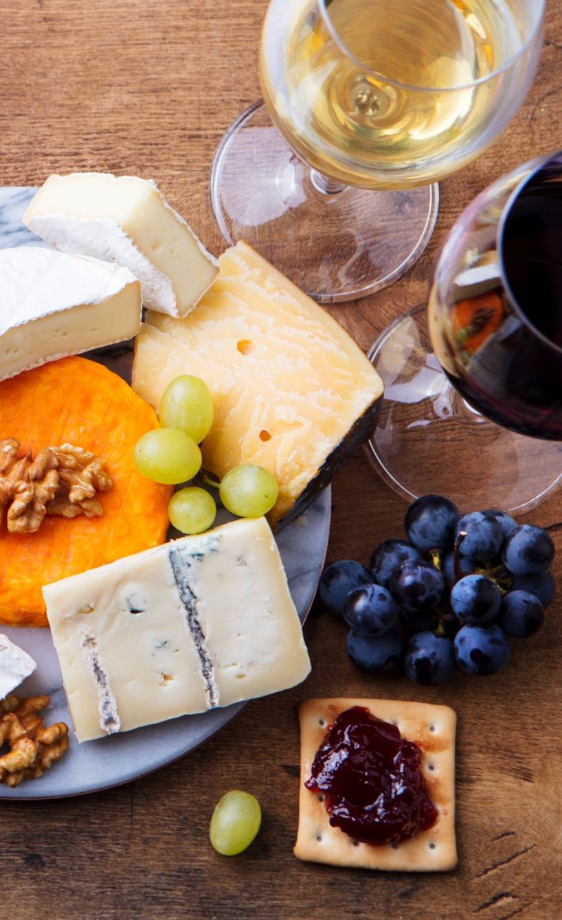 Ein Glas weißer und roter italienischer Wein neben einer Käseplatte Ein Glas weißer und roter italienischer Wein neben einer Käseplatte