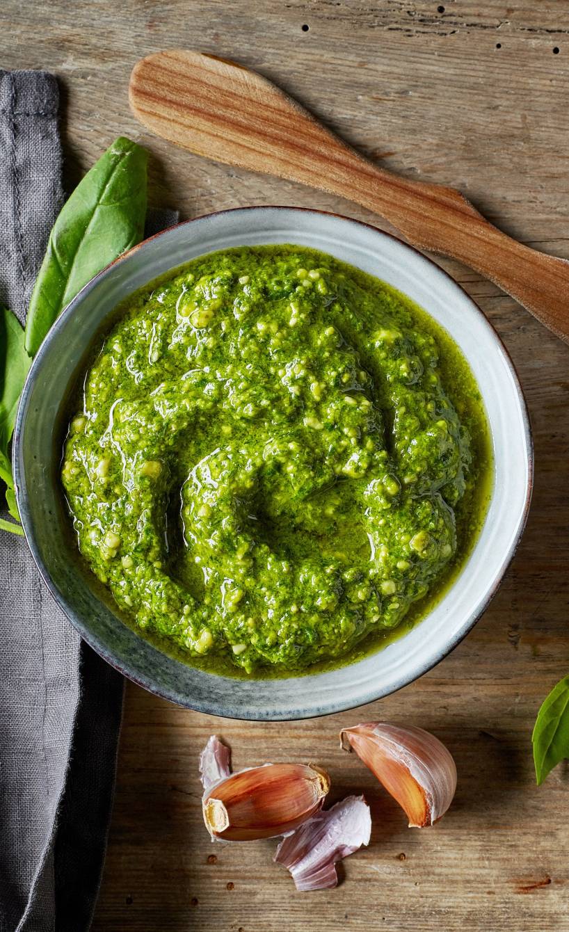 Selbstgemachtes grünes Pesto-Dressing in einer Schüssel auf einem Holztisch