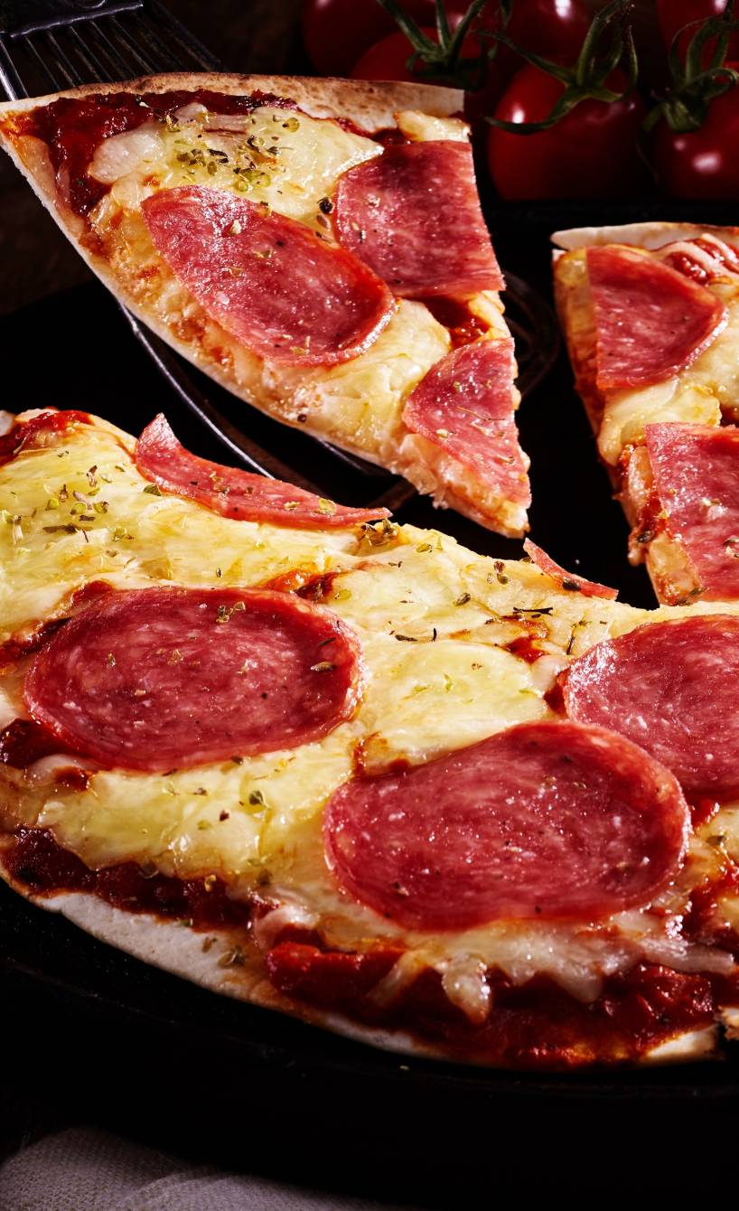 Wrap-Pizza belegt mit Salami und Käse in einer Pfanne Wrap-Pizza belegt mit Salami und Käse in einer Pfanne