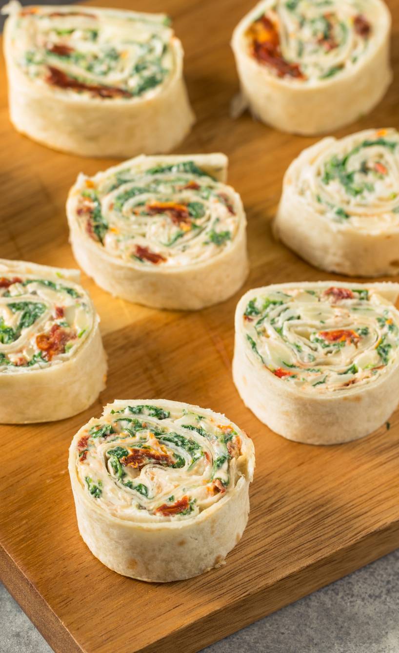 Selbstgemachte Pinwheel Wrap-Röllchen als Vorspeise auf einem Holzbrett angerichtet Selbstgemachte Pinwheel Wrap-Röllchen als Vorspeise auf einem Holzbrett angerichtet