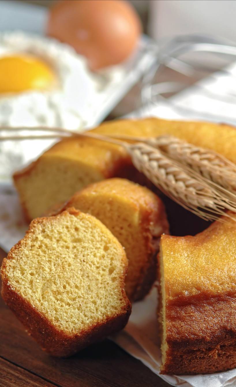 Ciambellone italienischer Zitronen-Rührkuchen angeschnitten auf einem Holzbrett