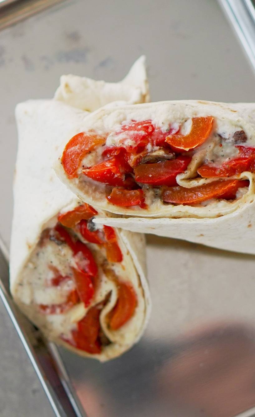 Halbierter Verdure e Cannellini Veggie-Power-Wrap auf einem Tablett Halbierter Verdure e Cannellini Veggie-Power-Wrap auf einem Tablett