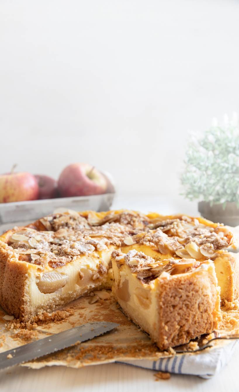 Bratapfelkuchen mit Pudding und Zimtstreuseln angeschnitten auf einer Kuchenplatte
