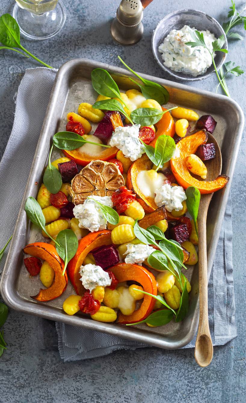 Gebackene Gnocchi, Kürbisspalten, Rote Bete und Knoblauch auf einem Ofenblech getoppt mit Feta-Dip