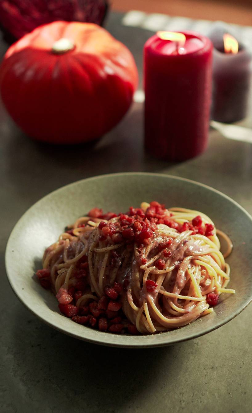 Spaghetti angerichtet mit lila Carbonara angerichtet auf einem Pastateller mit Speck und Käse