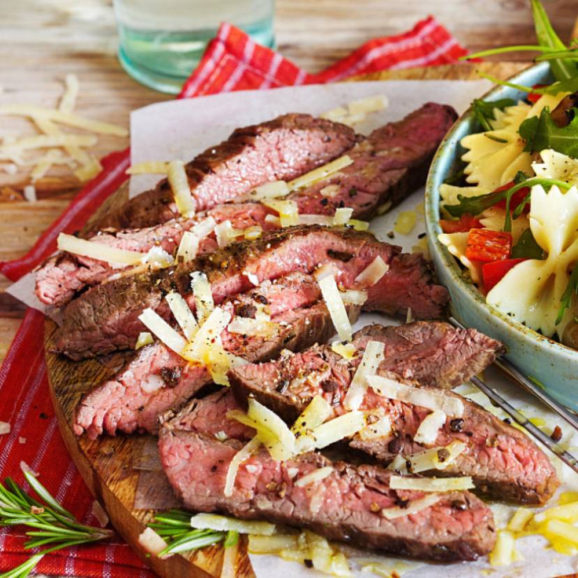 Italienischer Salat in einer Schüssel, daneben Grillfleisch