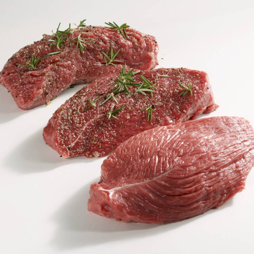 Drei rohe Stücke Tagliata vom Rind auf einem Tisch