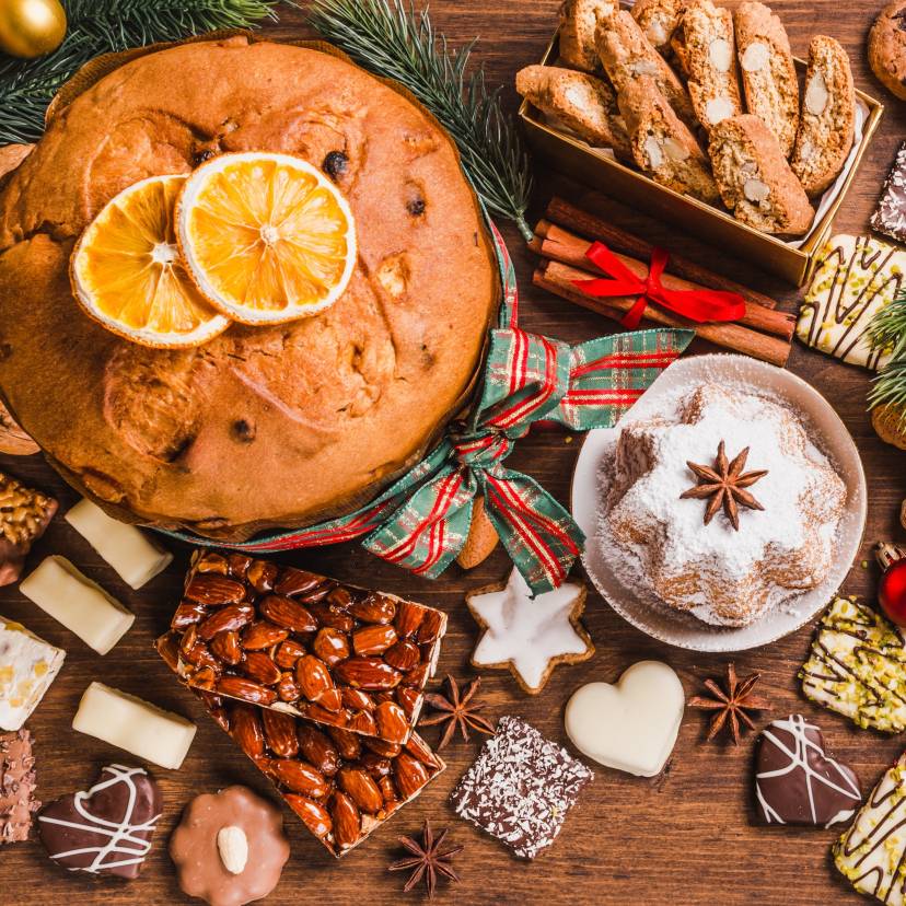 Verschiedene Weihnachtsplätzchen und Kuchen auf einem Holztisch in einer italienischen Küche