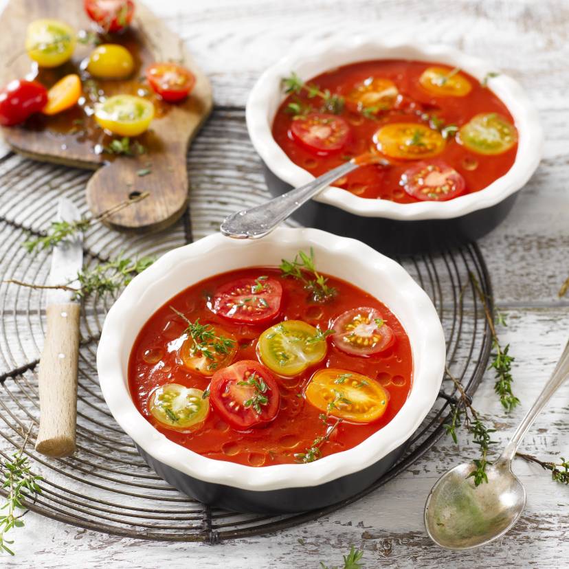 Zwei Suppenteller mit kalter Tomatensuppe auf einem Tisch