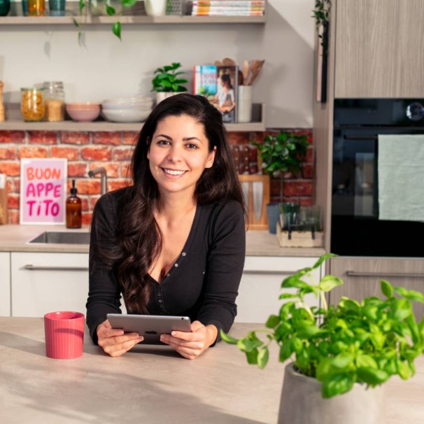 Serena Loddo in der So isst Italien Küche schaut via Tablet in den WhatsApp-Kanal