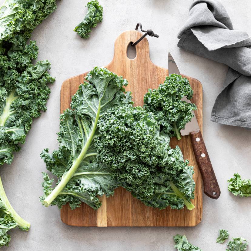 Frische Grünkohlblätter auf einem Holzbrett