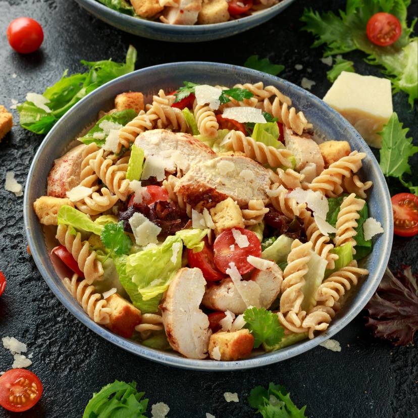Salat aus Resten von Nudeln, Brot und Hähnchen angerichtet mit Cherrytomaten in einer Salatschüssel